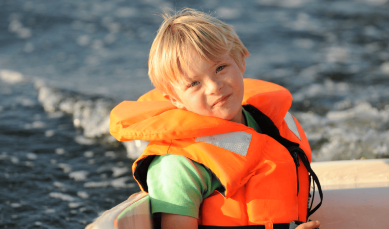 Child in Boat Wearing a Life Jacket